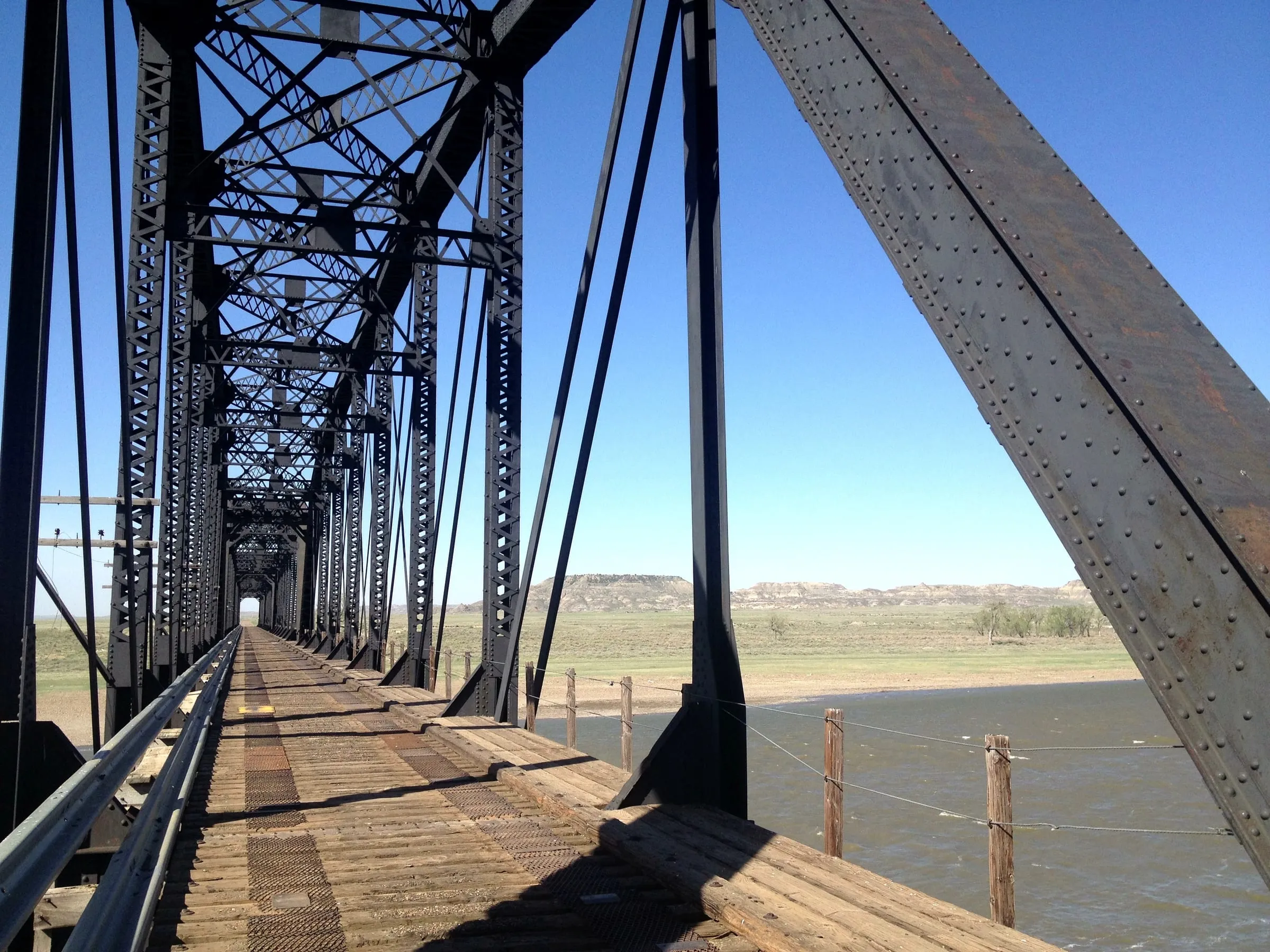 Looking along the deck of an old steel truss bridge over the Yellowstone River